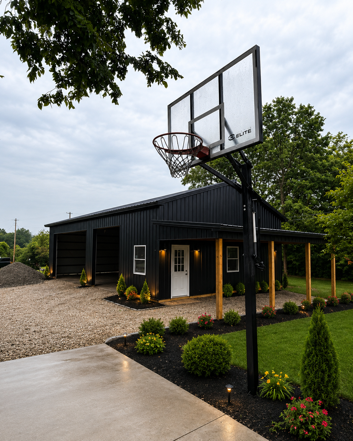 Black pole barn with porch and basketball hoop